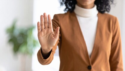 Ejecutiva levantando la mano con firmeza para establecer un límite claro, expresar una postura ética y proteger los valores fundamentales de su entorno profesional.