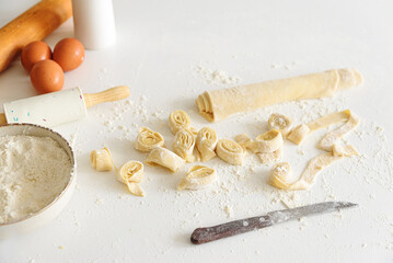 Ingredients and tools for making fresh homemade pasta on a floured surface.