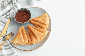 Crepes with chocolate cream and coffee on white wooden table. Pancake day, Maslenitsa. Top view