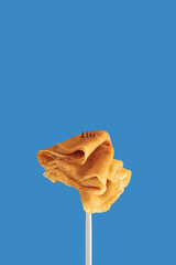 Golden pancakes on a fork against a vibrant blue background.