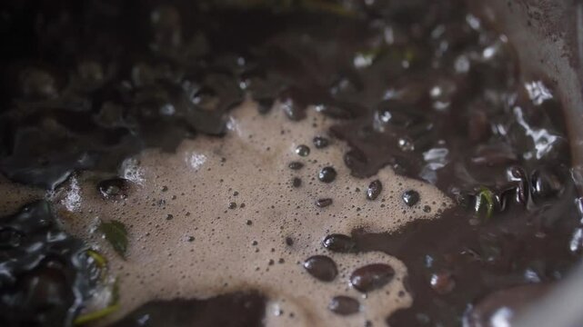 Close up of a Brazilian feijoada being cooked, black pork, vegetables, beef, sausage