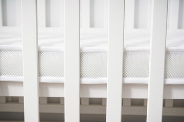 White wooden baby crib in bright minimalist nursery