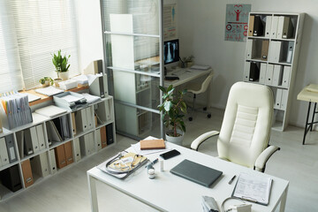 Empty medical office showing organized workspace with stethoscope, blood glucose meter, documents...