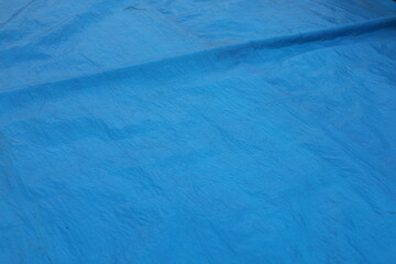 Background made of a sheet of blue plastic tarpaulin.