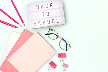Back to school. Lightbox with letters and stationery on a blue background. Place for your design.