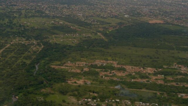 Point of view of a traveler from an airplane taking off over a landscape of houses in a rural area.