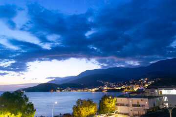 Twilight landscape of a resort Himare town located in a bay at the foot of the mountains. Ionian...