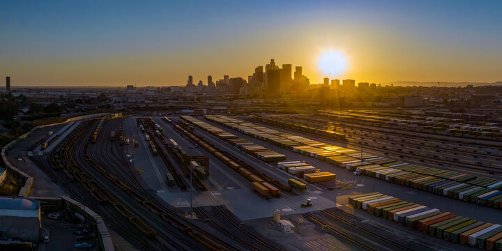 Sunset light rays reflecting off shipping containers in rail yard outside of downtown Los Angeles