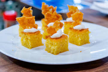 Gourmet cornbread bites with whipped topping and crisp garnish