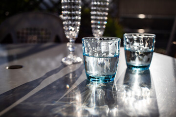 still life with vintage water and champagne glasses in the sun
