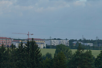 A slightly outoffocus image depicting a bustling cityscape featuring a tall crane visible in the...