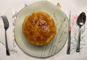 Soufflé served on a plate with gray details, on a tablecloth with floral and leaf patterns. To the...