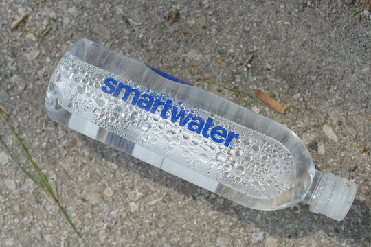 discarded bottle of "smartwater" by Glac&eacute;au (Coca-Cola) on the ground