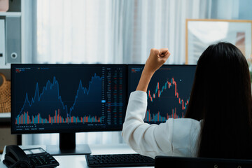 Successful young Asian businesswoman earning highest profit with fist up in exchange stock market...