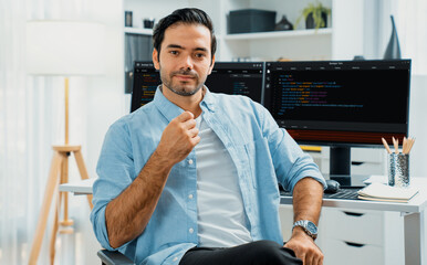 Profile's smart IT developer looking camera to pose against on software development coding on two...