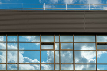 Modern architecture reflects vibrant clouds under a bright blue sky in this urban setting