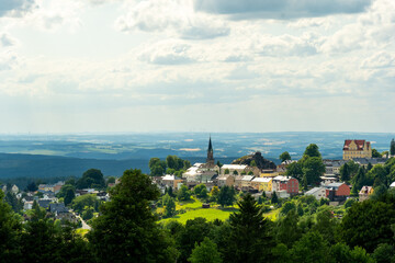 Charming hilltop village with lush greenery and rolling hills during a sunny afternoon in summer