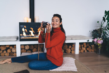 Woman posing with analog camera in cozy environment, symbolizing creative freedom and human...