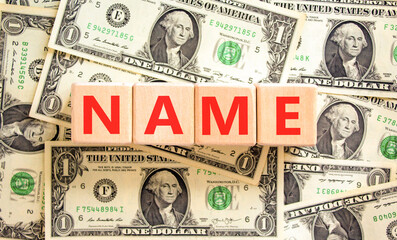 Name symbol. Concept word Name on beautiful wooden blocks. Dollar bills. Beautiful background from...