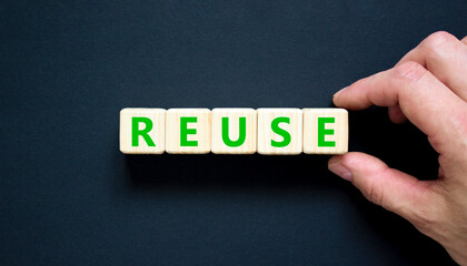 Reuse symbol. Concept word Reuse on beautiful wooden blocks. Beautiful black table black...