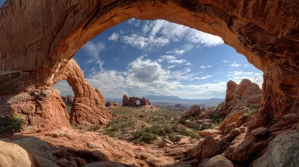 Gordijnen Wide angle landscape revealing double arch framing turret arch against blue sky, white clouds at arches national park, utah © Newleks