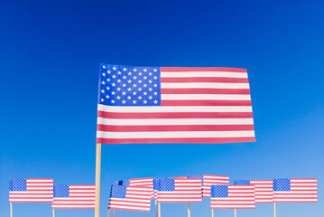 Multiple American Flags on Independence Day. Concept of national unity and Independence Day celebration. Several American flags waving together against a vibrant blue sky, symbolizing patriotism