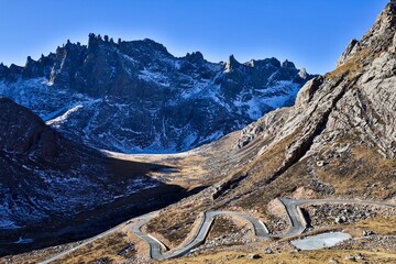 Winding mountain road leading to the dramatic jagged peaks of Nyenpo Yutse in Lianbao Yeze Geological Park near Ngawa, historical Amdo region of Greater Tibet.