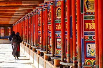 Pilgrims walk along the colorful prayer wheel corridor at Labrang Monastery, home to the longest Tibetan circumambulation path in the world.
