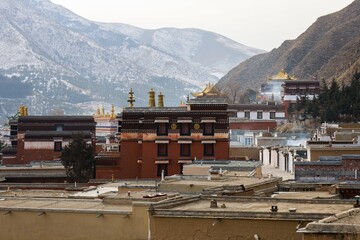 Labrang Monastery complex with golden rooftops set against the mountain backdrop, a major Tibetan...