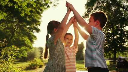 Children teamwork, group of children play in park. Boy girl greet hands. Successful team of kids winners. Family teamwork. Friends together outdoors. Outdoor games, concept of success, victory.