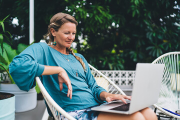 Professional freelancer using laptop in rooftop workspace with notebook and pen, illustrating...