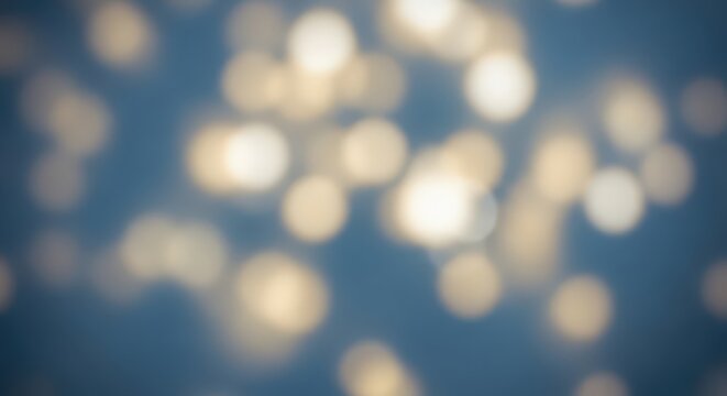 Golden bokeh light background on blue for funeral, memorial or remembrance card. Abstract bright blurred effect for mourning backdrop.
