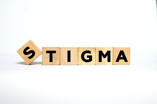 The word "STIGMA" spelled out using wooden blocks with bold black letters on a clean white background.