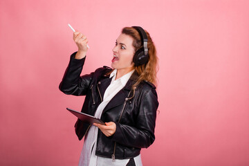 Woman with headphones, listening to music, fashion model in studio posing, music genre, smiling, rock, metal music , tablet