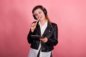 Woman with headphones, listening to music, fashion model in studio posing, music genre, smiling, rock, metal music , tablet