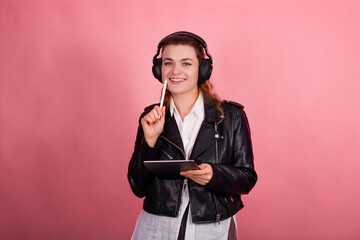 Woman with headphones, listening to music, fashion model in studio posing, music genre, smiling, rock, metal music , tablet