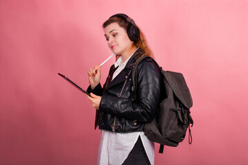 Woman with headphones, listening to music, fashion model in studio posing, music genre, smiling, rock, metal music , tablet