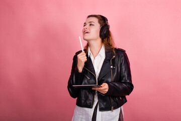 Woman with headphones, listening to music, fashion model in studio posing, music genre, smiling, rock, metal music , tablet