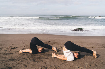 Two men in plow pose with interlocked fingers demonstrate full surrender and synchronized...