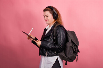Woman with headphones, listening to music, fashion model in studio posing, music genre, smiling, rock, metal music , tablet
