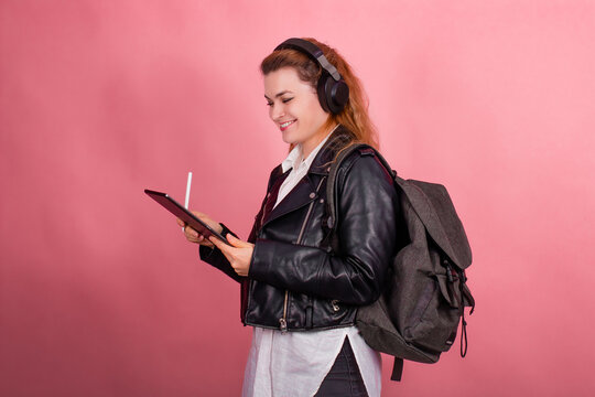 Woman with headphones, listening to music, fashion model in studio posing, music genre, smiling, rock, metal music , tablet