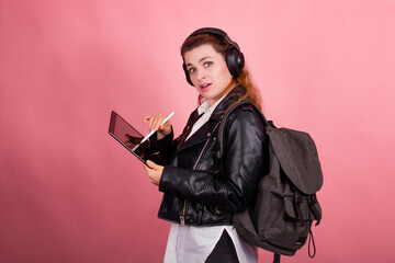 Woman with headphones, listening to music, fashion model in studio posing, music genre, smiling, rock, metal music , tablet