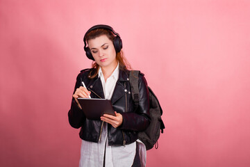 Woman with headphones, listening to music, fashion model in studio posing, music genre, smiling, rock, metal music , tablet