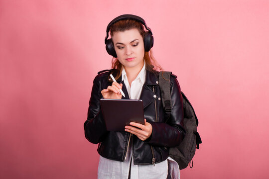 Woman with headphones, listening to music, fashion model in studio posing, music genre, smiling, rock, metal music , tablet