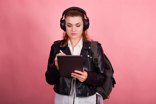 Woman with headphones, listening to music, fashion model in studio posing, music genre, smiling, rock, metal music , tablet