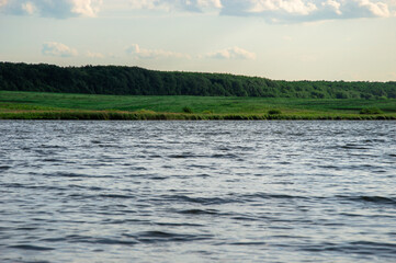 A tranquil river winds through vibrant greenery, reflecting the soft hues of twilight, creating a peaceful natural setting