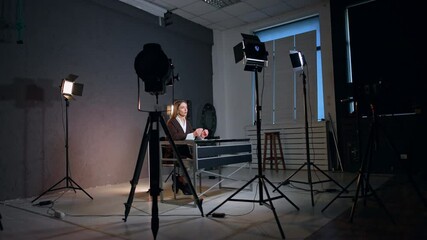 Soffits surround the lady sitting at desk in photo studio. Process of recording a blog or program. - Powered by Adobe