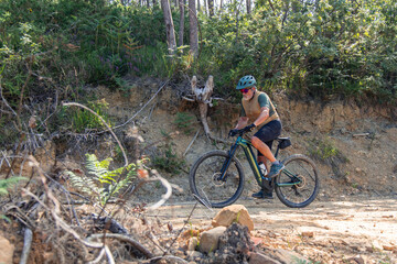 Senior man riding electric mountain bike on a forest trail