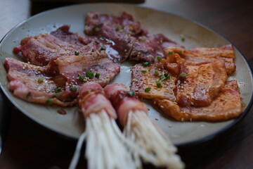 Various seafood such as enoki mushrooms, shrimp and sausages are being grilled by food vendors.