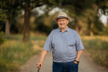 Grandfather in a hat. Portrait of a very old Caucasian man. Portrait: elderly, lonely, elderly, with many wrinkles on his face. Close-up of a thoughtful old man standing alone outdoors.